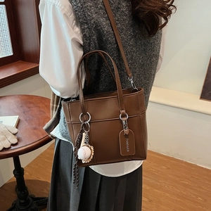 Borsa a secchiello a spalla in pelle marrone per donna con ciondolo da baseball