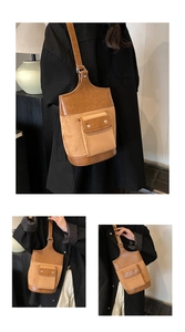 Detail of vintage suede bucket bag featuring contrast stitching and metal buckles