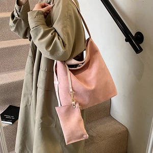 Grand sac cabas rose en faux daim avec pochette assortie porté par un mannequin