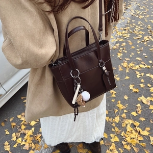 Borsa a secchiello minimalista marrone scuro con tracolla e ciondoli da baseball
