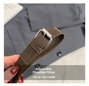 Detail showing the adjustable brown leather strap with silver buckle and fine stitching