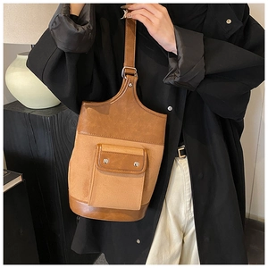 Detail of vintage brown suede and glossy leather patchwork bag shown on a female model