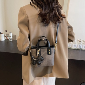 Retro grey matte bucket bag with a cute dog charm and adjustable shoulder strap