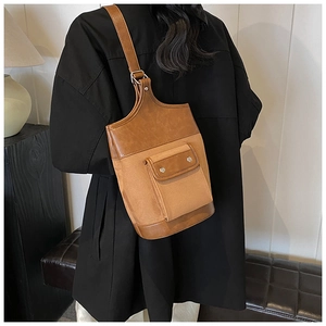 Detail of vintage brown bucket bag showing contrast of faux leather and suede materials