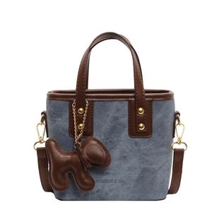 Blue denim and brown leather bucket bag with dog pendant and detachable strap