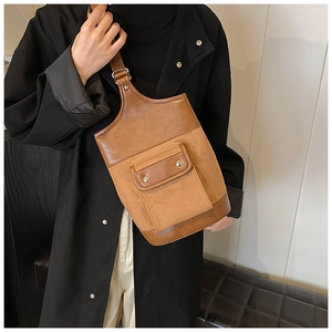 Detail of vintage brown suede crossbody bag with metal rivet flap pocket and adjustable strap