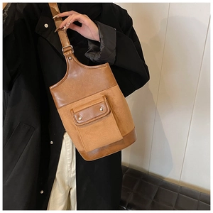 Detail of suede and smooth leather stitching bucket bag with silver metal buckle