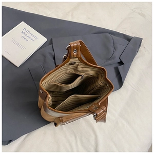 Detail of suede bucket bag interior with striped lining and secure zippered pocket