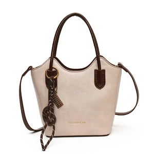 Elegante bolso tipo cubo beige con asas marrones y detalle de anillo dorado para mujer