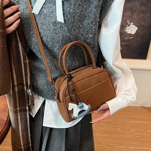 Brown matte bowling bag with horse charm and crossbody strap for women