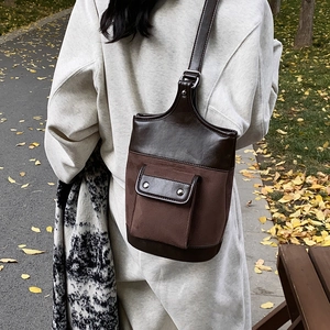 Retro brown suede bucket bag shoulder bag for women shown in a scenic autumn outdoor setting