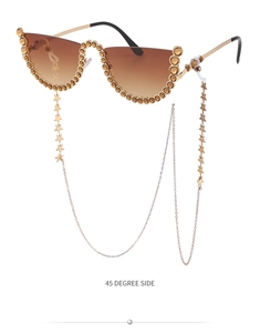 Détail de lunettes de soleil œil de chat sans monture avec strass jaunes et chaînes étoiles