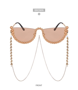 Détail de lunettes de soleil sans monture marron avec strass et chaîne d'étoiles dorées