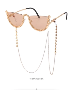 Détail de lunettes de soleil sans monture avec strass champagne et chaîne à étoiles