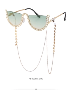 Détail de lunettes de soleil sans monture, verres verts, strass et chaîne d'étoiles