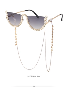 Détail de lunettes de soleil sans monture avec strass et chaîne dorée à étoiles