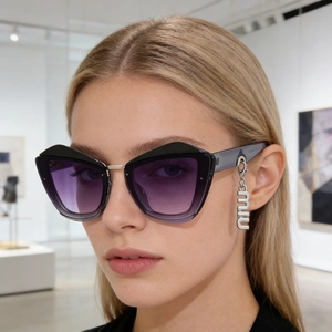 Détail de lunettes œil de chat avec pendentif lettre argentée sur la branche noire