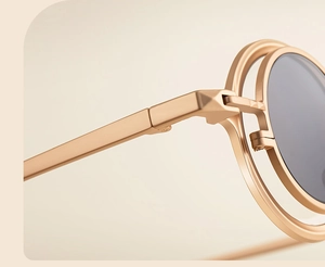 Detailed macro view of high-quality metal hinges and rose gold temples on round sunglasses