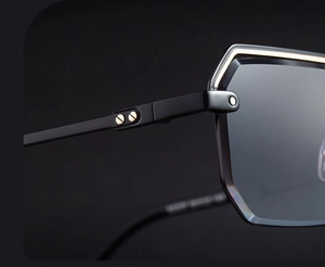 Détail des verres à bords géométriques et des vis dorées sur les lunettes de soleil noires