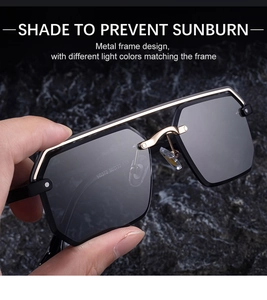 Détail de lunettes de soleil carrées sans monture avec cadre doré et verres gris foncés