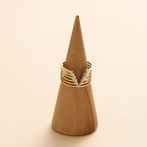 Detailed view of gold V-shaped crystal ring on a wooden stand with layered hollow design