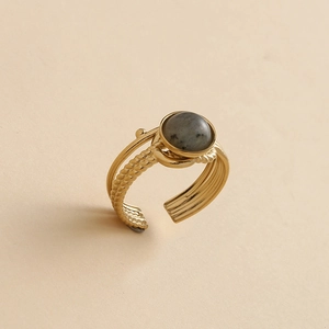 Macro detail of 14K gold-plated adjustable ring with grey gemstone and woven texture