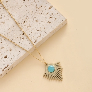 Minimalistische 14K Goldhalskette mit Türkis-Sonnenanhänger auf einem Stein
