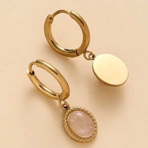 Detail of 14K gold plated hoop earrings with oval pink gemstone pendant in macro view