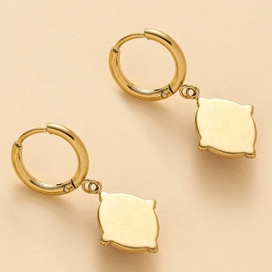 Vue détaillée des boucles d'oreilles créoles dorées en acier poli avec pendentifs