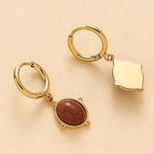 Détail de créoles dorées avec pendentifs ovales en pierre goldstone brune et dos en métal