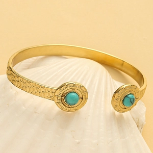 Detail of 14K gold plated hammered cuff bracelet featuring turquoise stone inlays