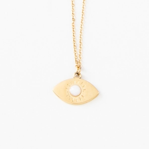 Close-up of eye-shaped gold pendant necklace with sunburst texture and white stone