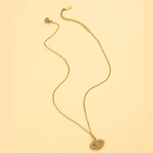 Détail du collier avec pendentif œil bleu, fermoir mousqueton et chaîne d'extension dorée