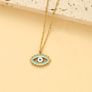 Détail du collier œil protecteur doré avec pendentif en émail bleu sur support pierre