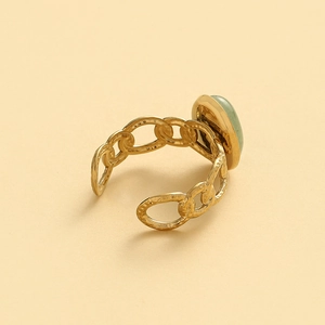 Detail of adjustable gold chain ring featuring a soft green oval stone setting