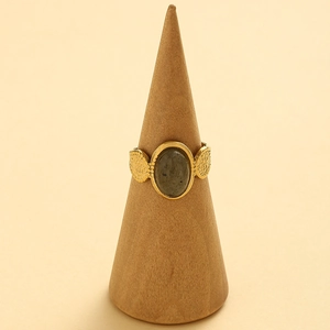 Close-up of golden adjustable ring with oval grey stone and hammered texture detail