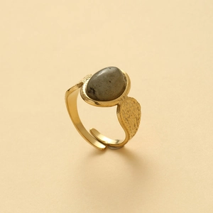 Detail of gold open ring featuring oval grey stone and vintage hammered texture finish