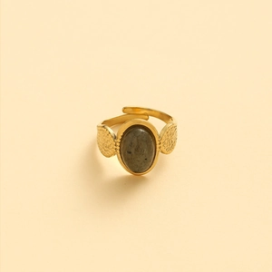 Detailed view of the open gold ring featuring an oval grey stone and hammered metal texture