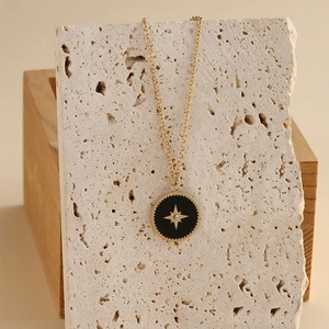 Halskette aus Edelstahl in Gold mit rundem Anhänger aus schwarzer Emaille und Stern