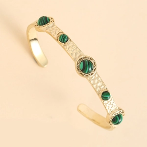 Détail d'un bracelet ouvert ajustable incrusté de turquoise avec finition dorée vintage