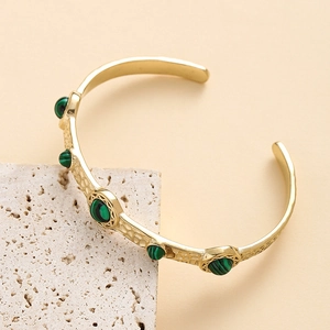 Bracelet jonc ouvert en acier doré martelé orné de cinq pierres turquoises vertes