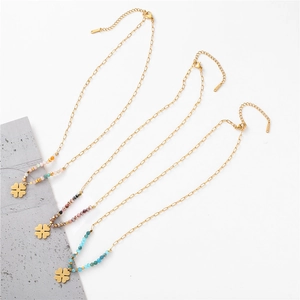 Detail of clover necklaces with gold chains, colorful beads, and lobster claw clasps