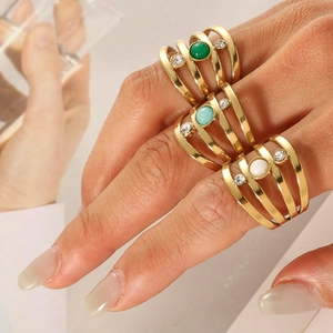 Detail of layered gold stainless steel rings with colorful natural stones and crystals