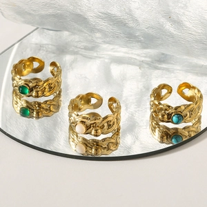 Detailed view of vintage gold twisted rings with green, white, and turquoise gemstones