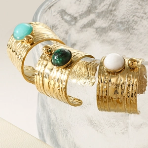 Detail of adjustable stainless steel rings with vintage gemstone inlays and hammered gold texture