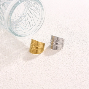 Detail of gold and silver textured wave rings with rippled metal surfaces on white texture