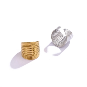 Set of gold and silver chunky hollow wave rings with textured linear design in minimalist style
