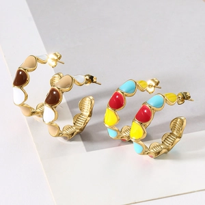 Detail of wave-edged C-shape earrings with colorful enamel patterns and gold finish
