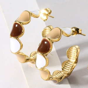 Detail of gold C-shaped hoop earrings with colorful marble drip glaze and inner texture