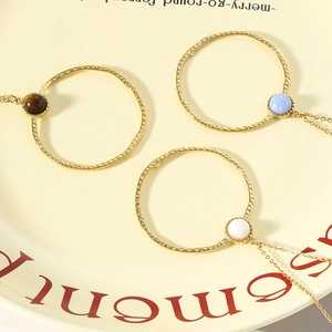 18K gold plated stainless steel necklaces with natural stones on a cream ceramic plate